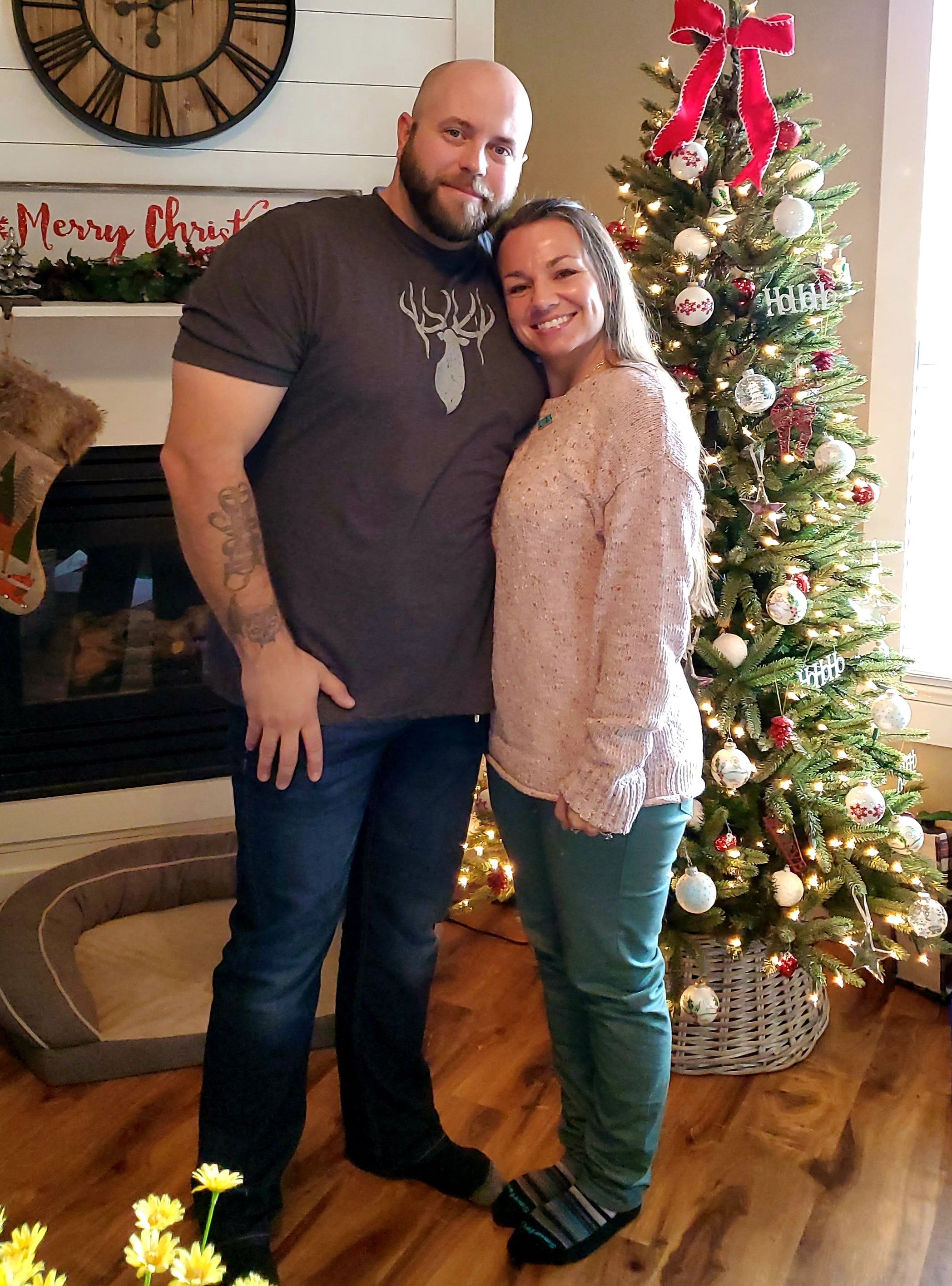Beef tallow maker and her husband standing in front of a Christmas tree in a home setting.